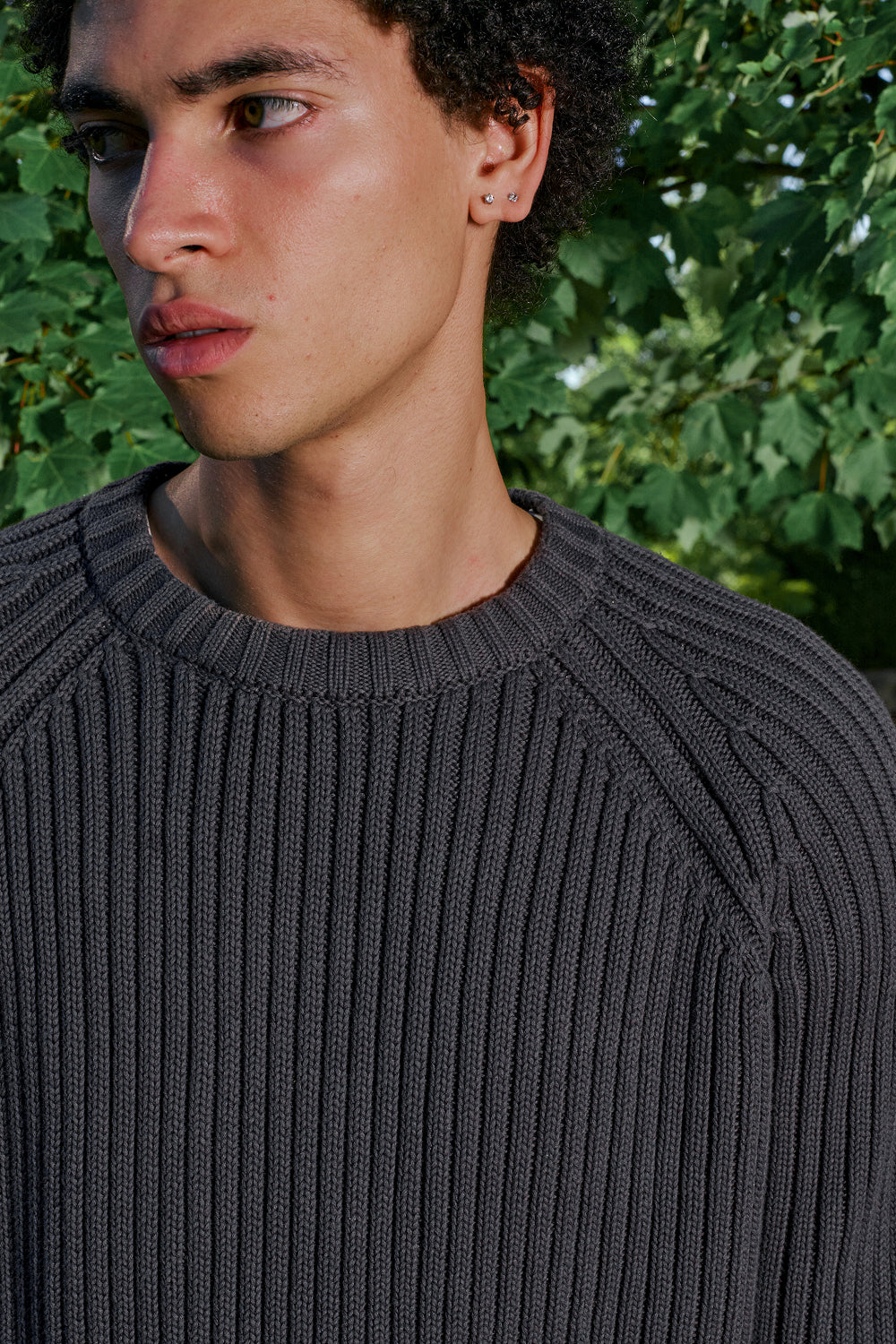 Close-up of black ribbed knit sweater with raglan sleeve detail.