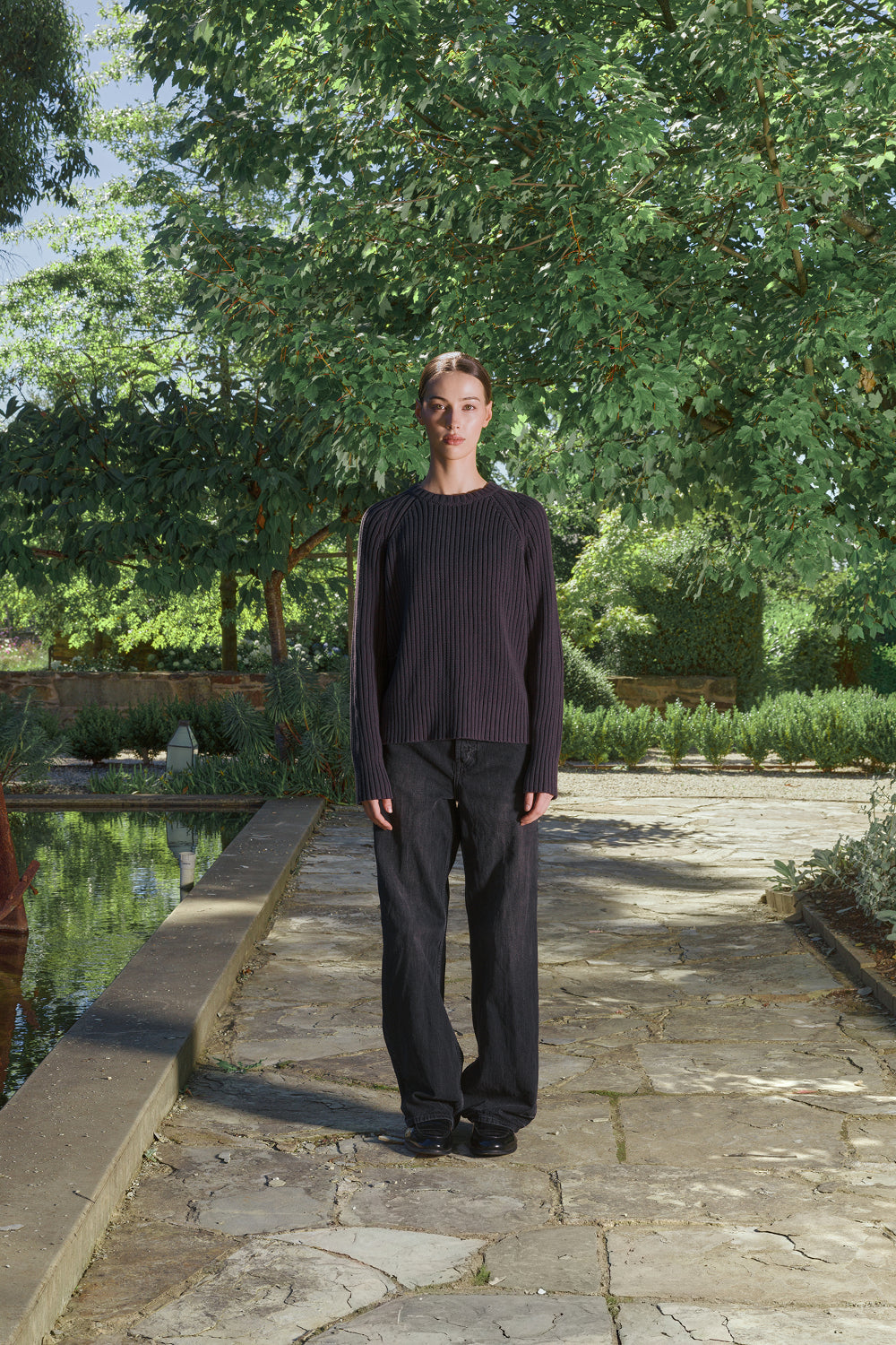 Model wearing a black ribbed knit sweater.