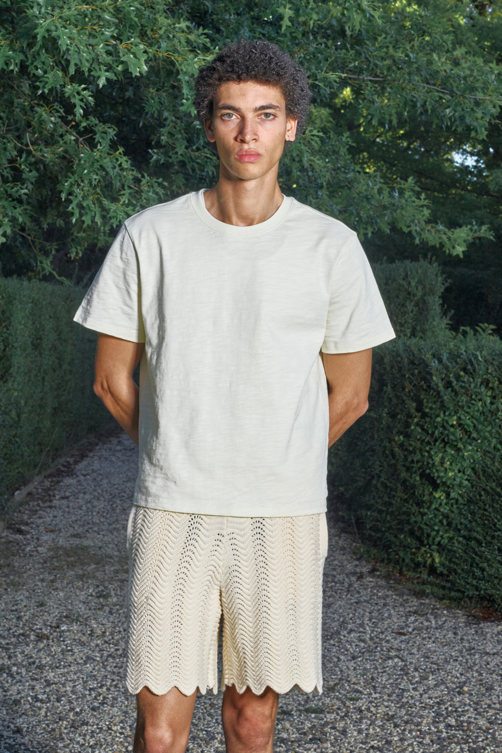 Model wearing Ivory shale stitch knit shorts with a white T-shirt.