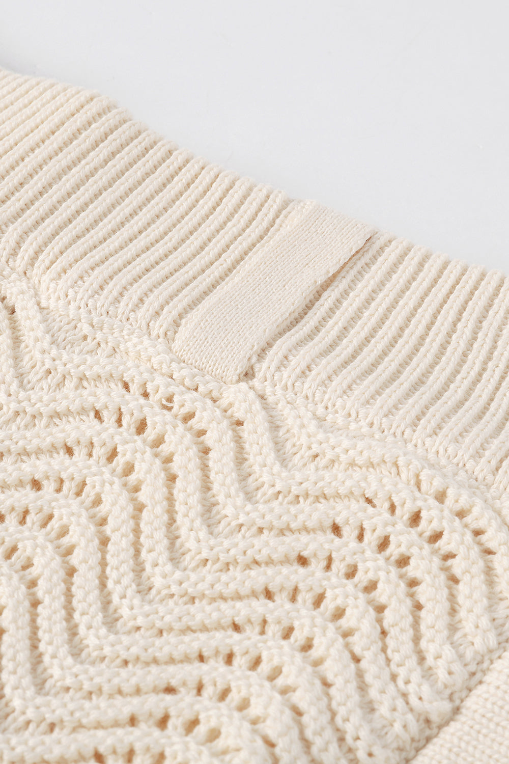 Close-up of ivory shale stitch knit shorts with ribbed waistband.