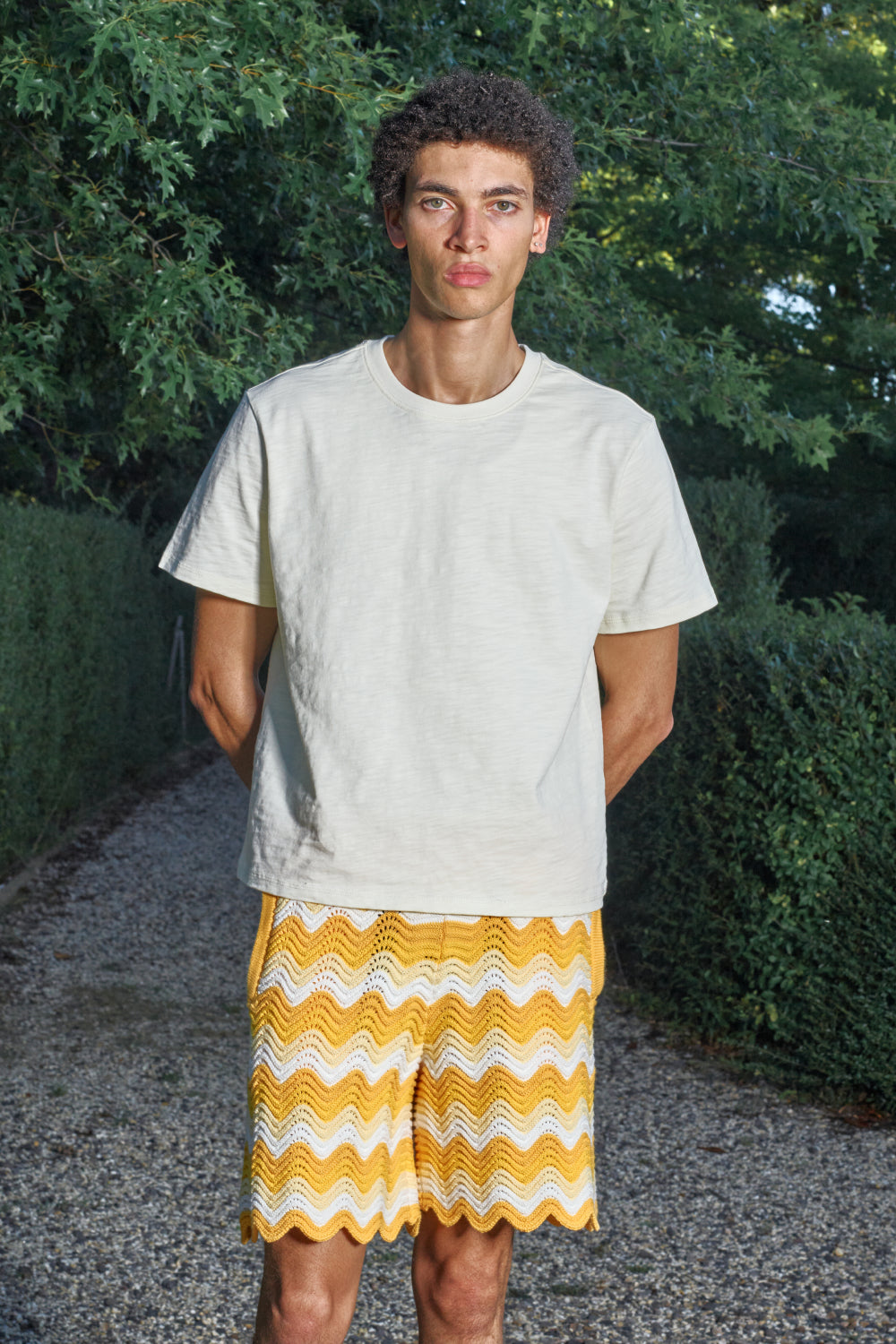 Model wearing yellow and white shale stitch knit shorts.