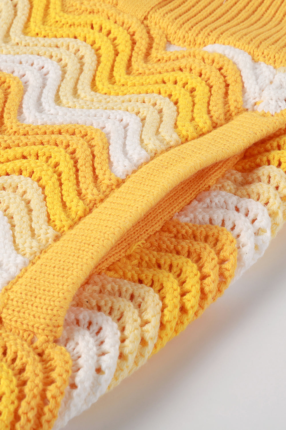 Close-up of yellow and white shale stitch knit shorts with side pocket.