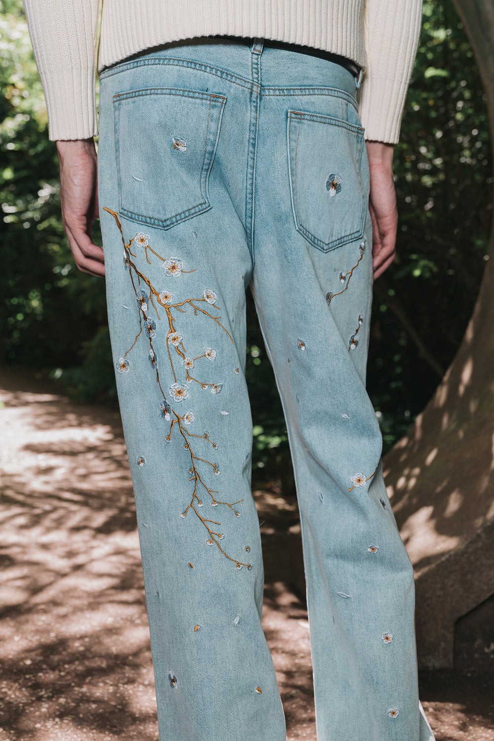 Back view of light blue embroidered denim jeans worn by a model.