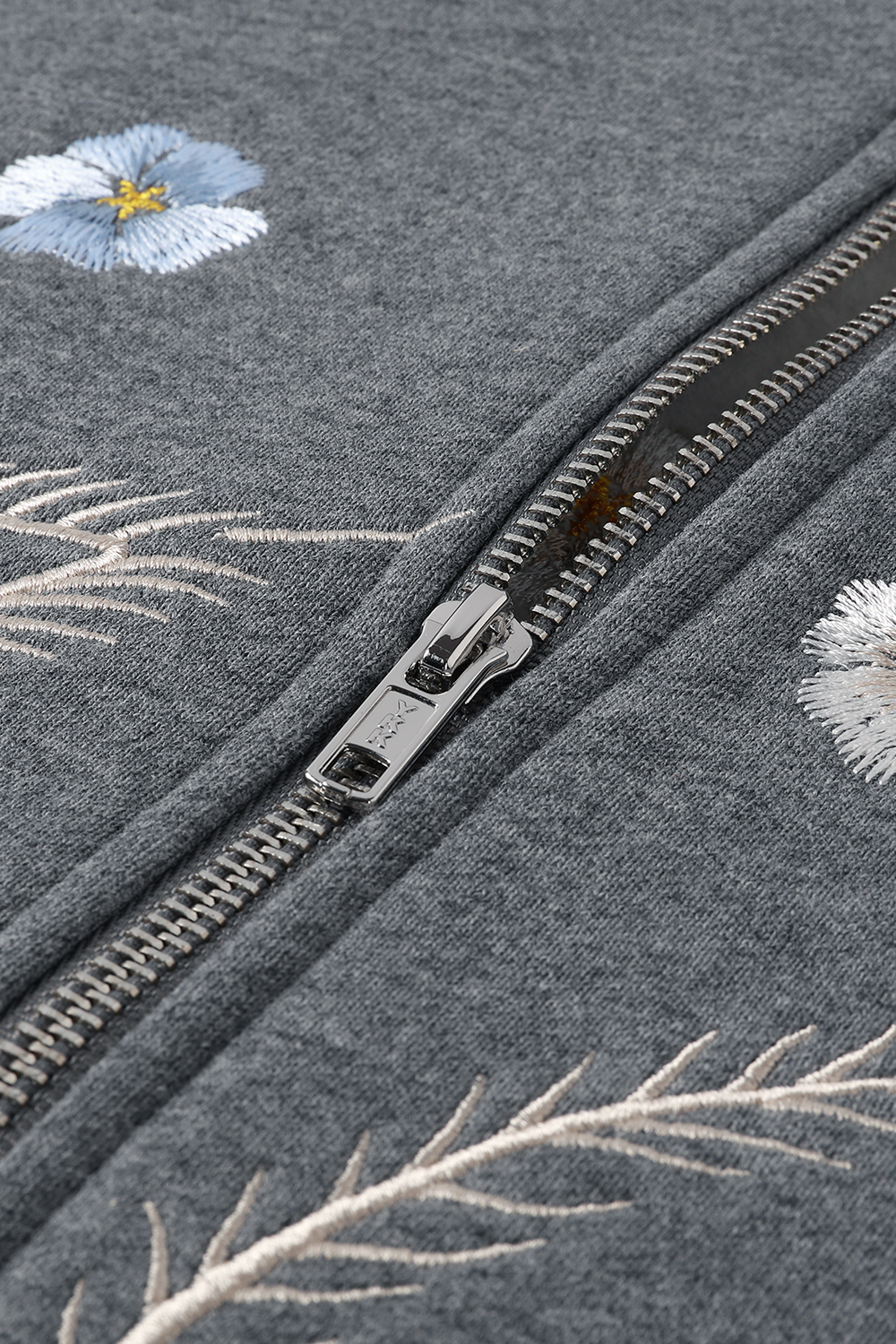 Grey fabric with floral embroidery and a YKK zipper