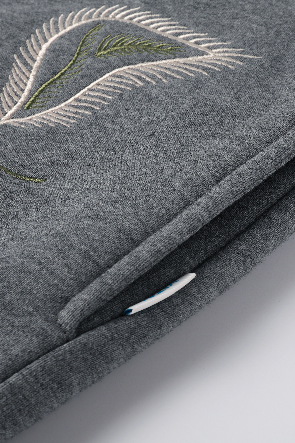 Close up view of the grey hoodie's side pocket.