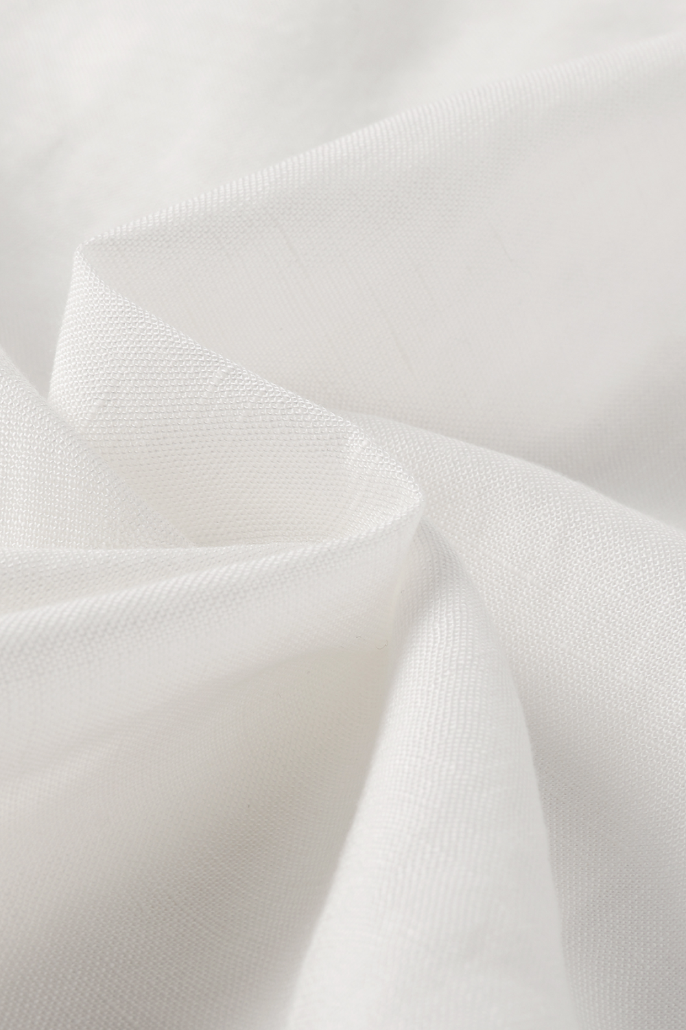 A close-up of draped white fabric with soft folds and a subtle texture.
