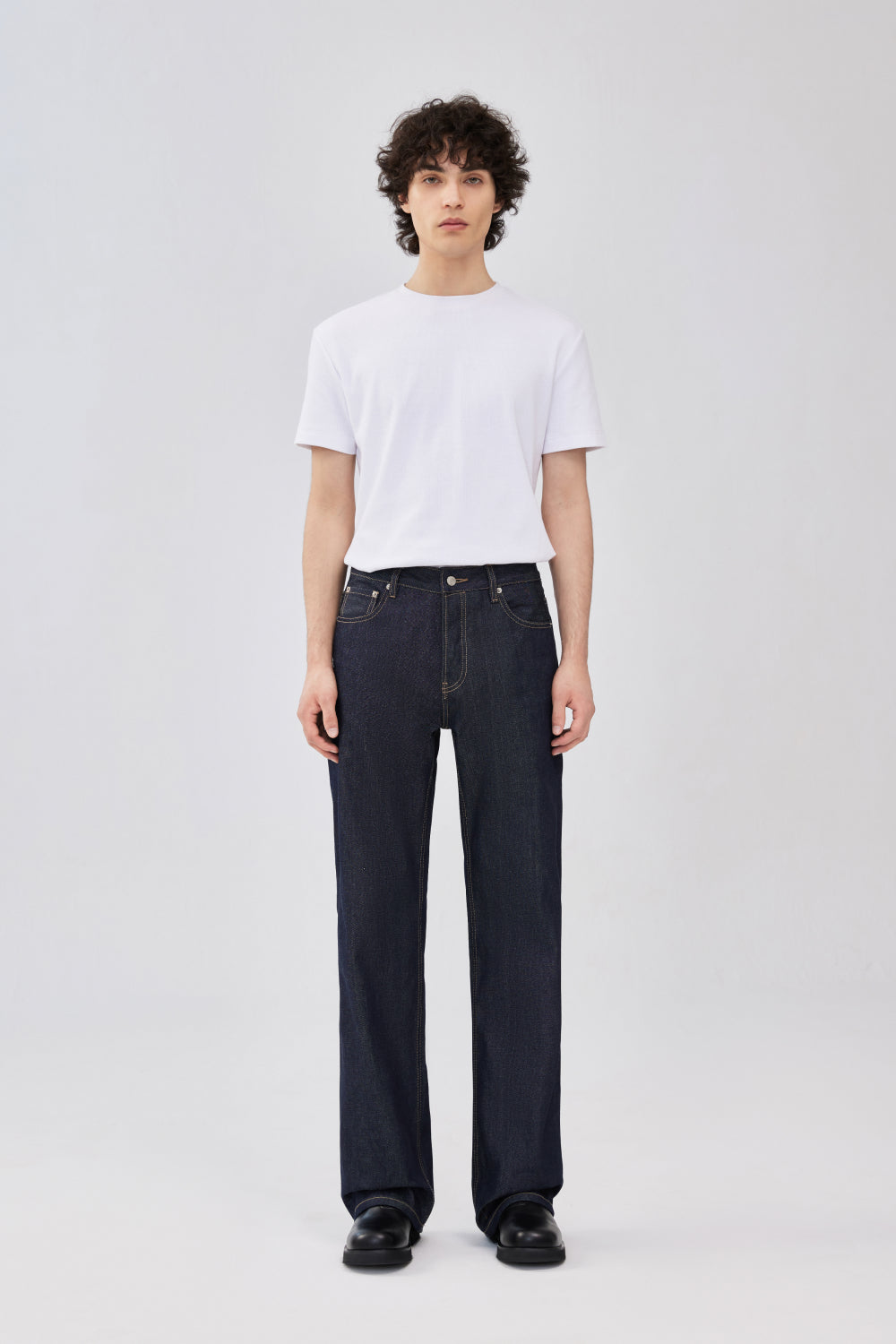 Front view of a model wearing indigo blue selvedge denim jeans.