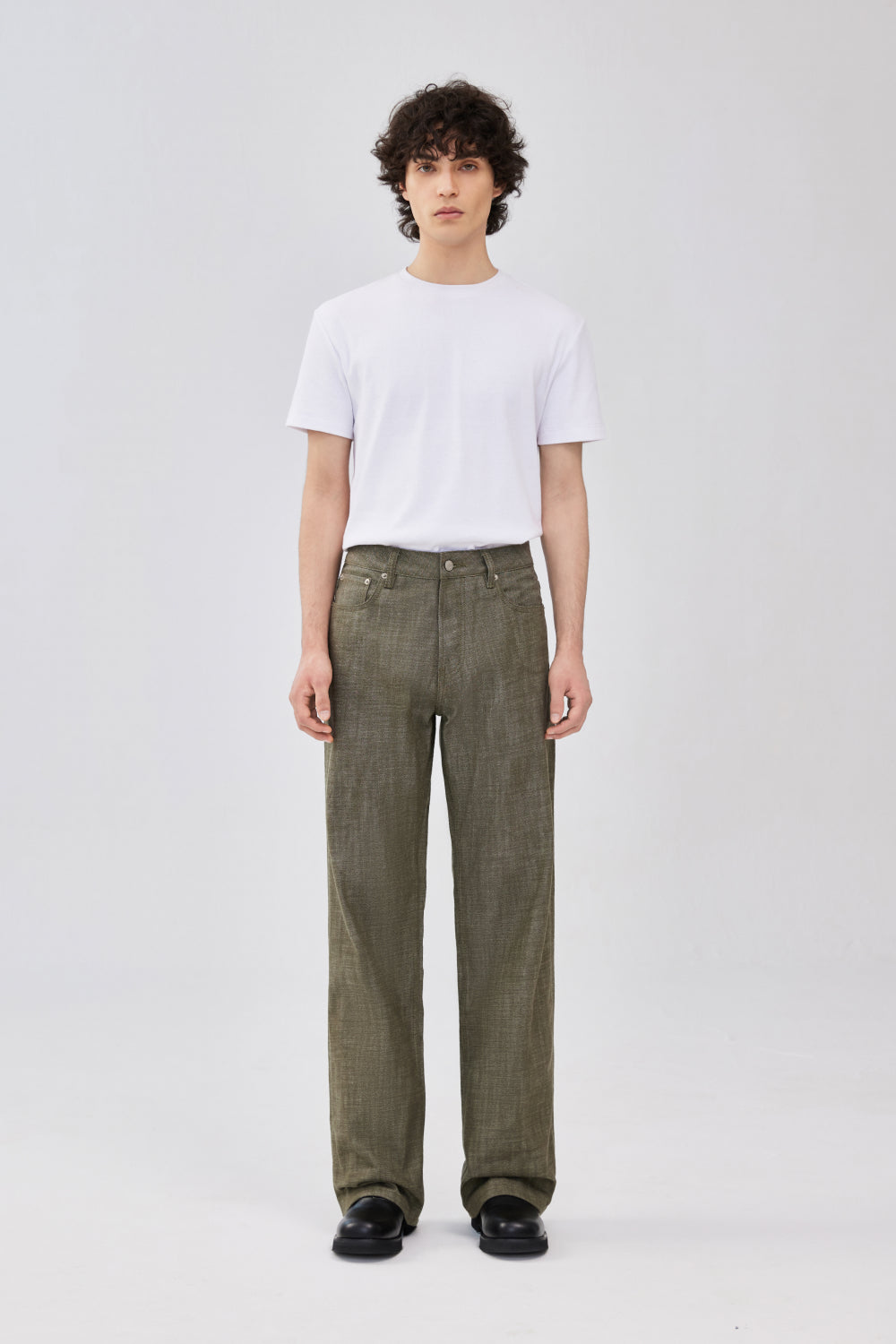 A model wearing military green selvedge straight-leg denim jeans.