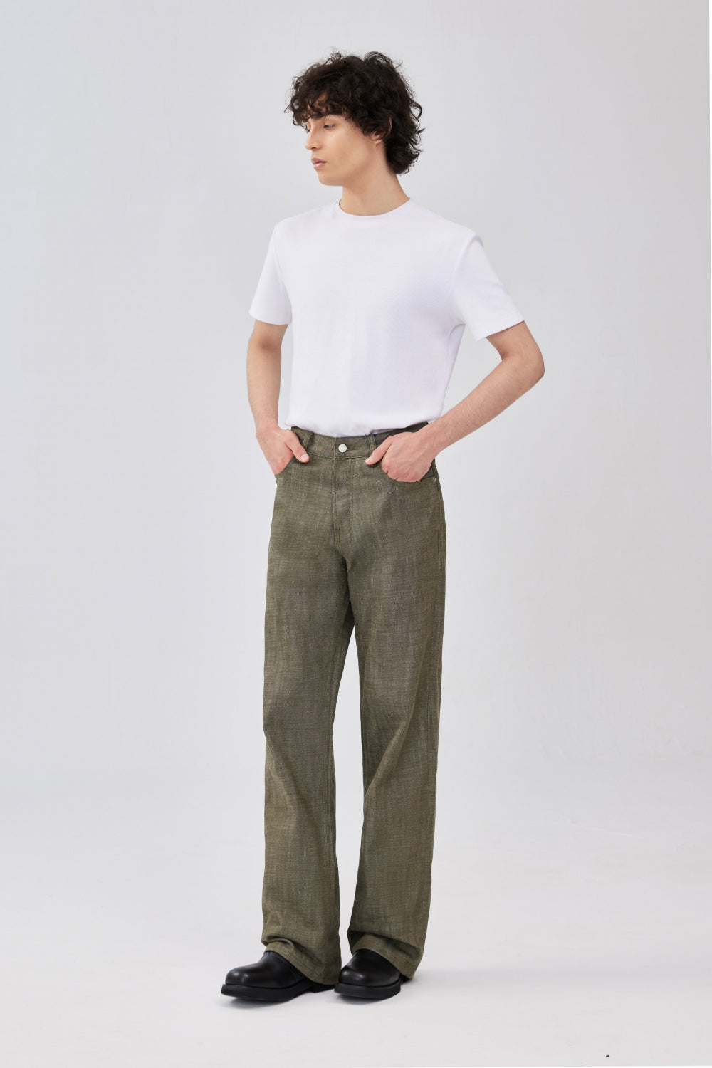 Side-front view of military green selvedge denim straight-leg denim jeans on a model.