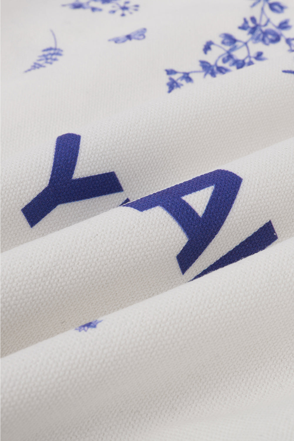 Close-up of white fabric with blue floral patterns and text