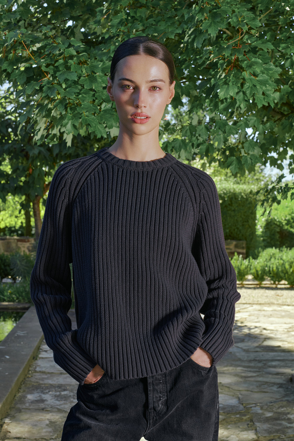 Model wearing a black ribbed knit sweater.
