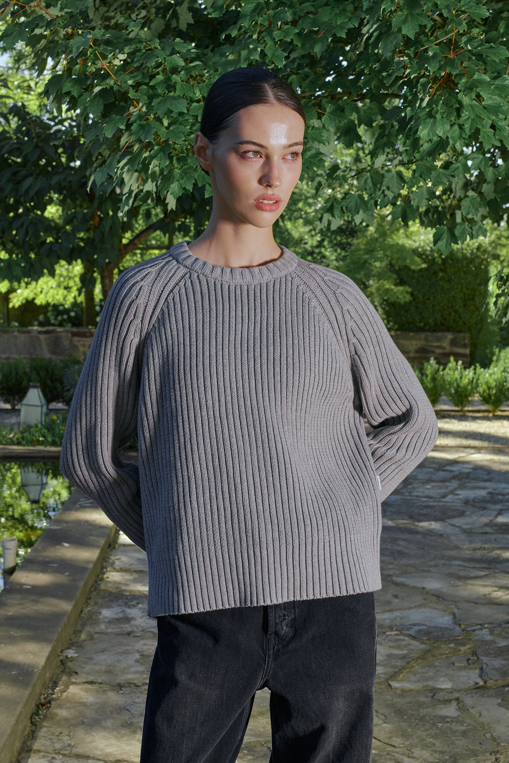 Close up view for Model wearing a grey ribbed knit sweater.