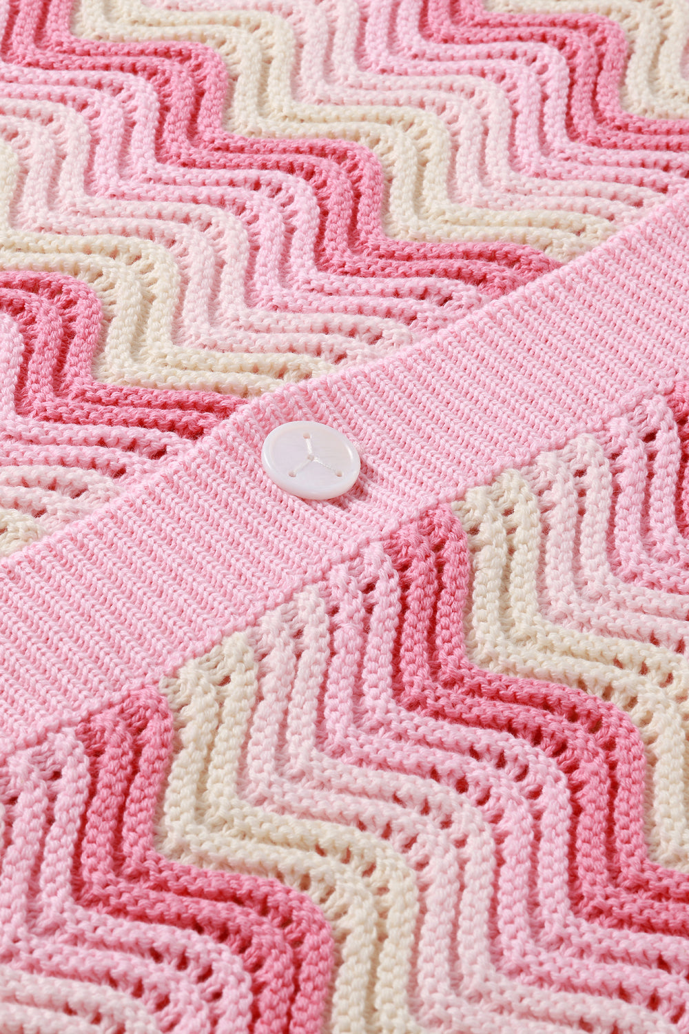 Close-up of Pink and cream shale stitch shirt with white button.