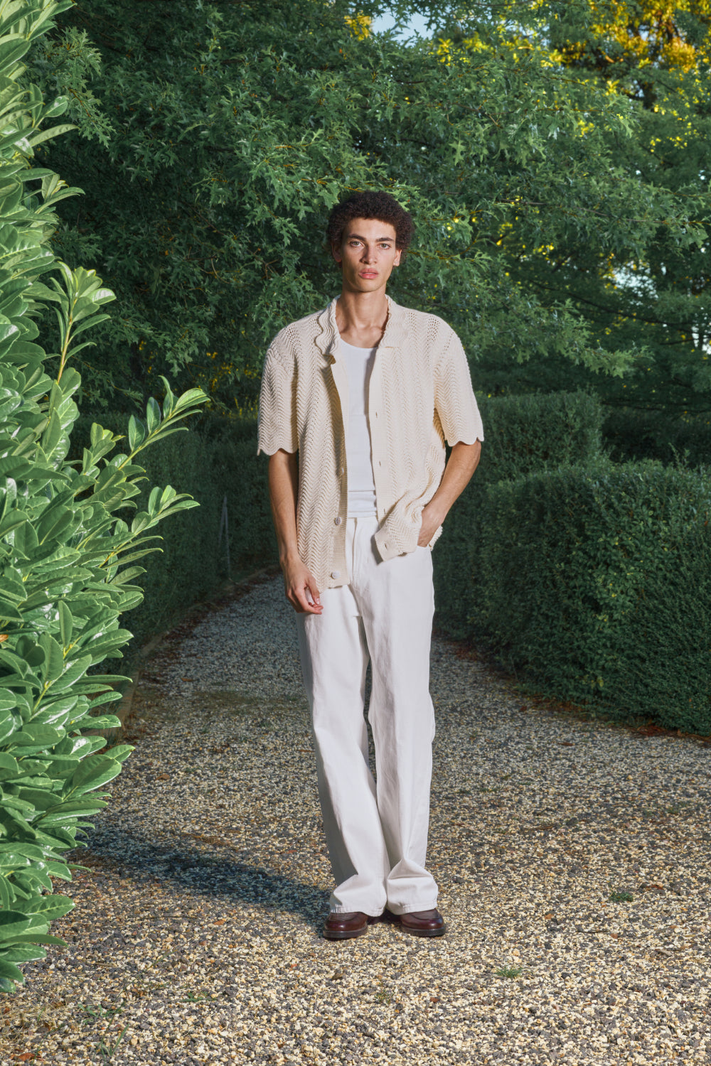 Model wearing an Ivory shale stitch shirt over a white top and light pants.