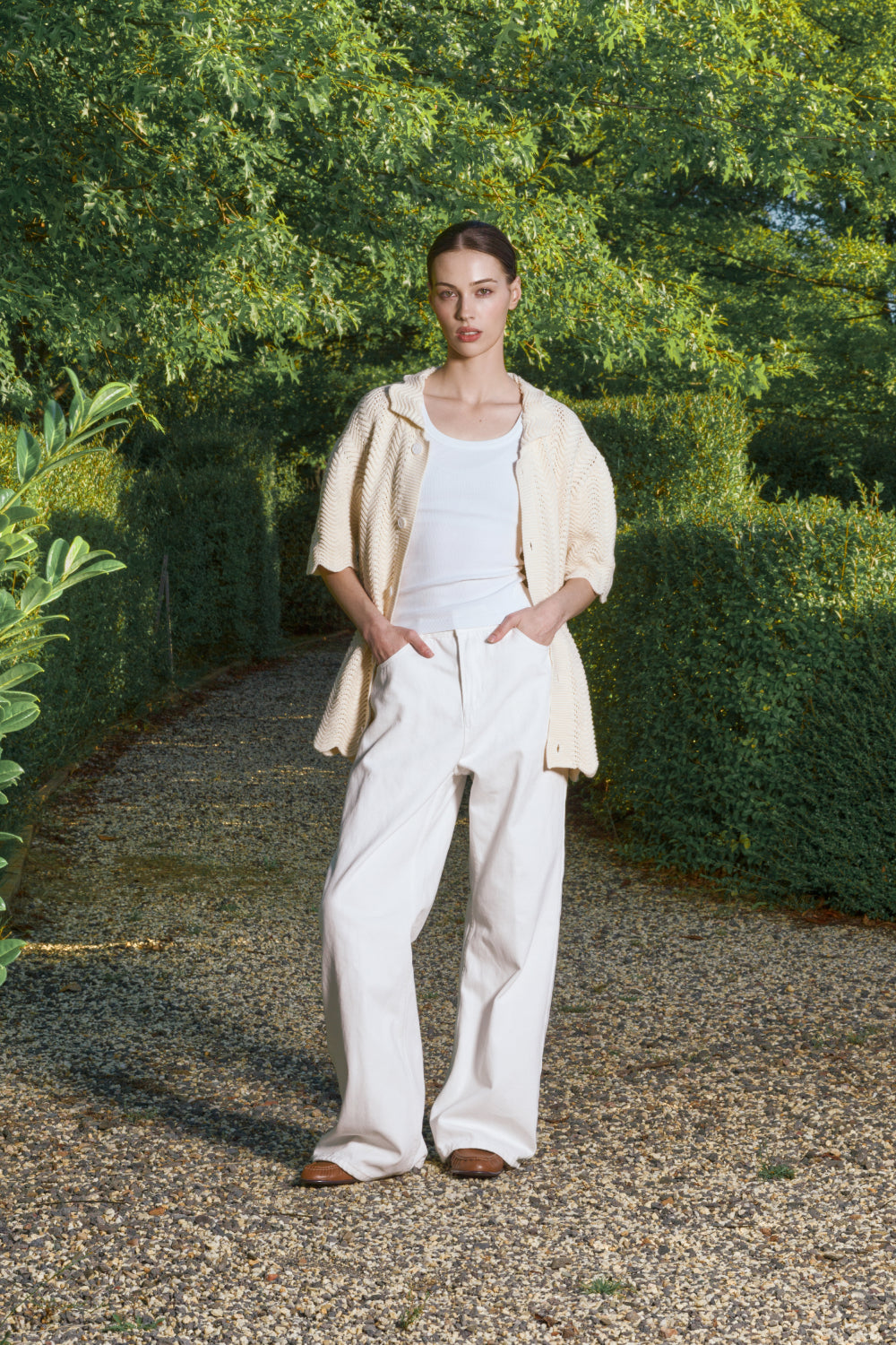 Model wearing an Ivory shale stitch shirt over a white top and light pants.
