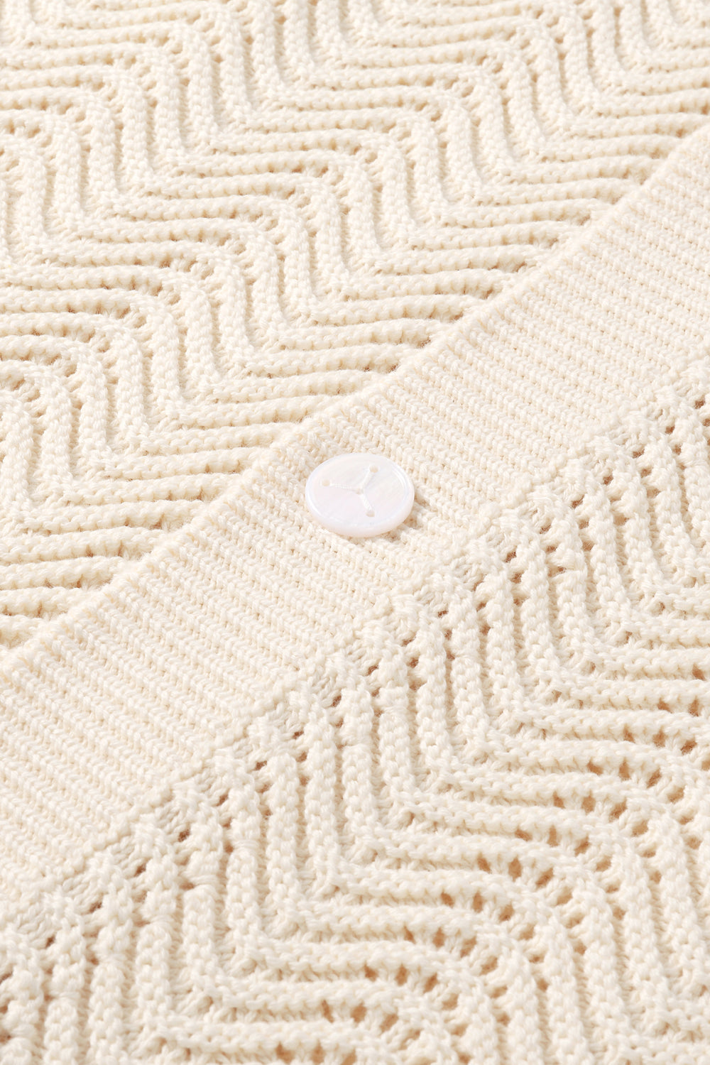 Close-up of shale stitch knit  fabric with a button.