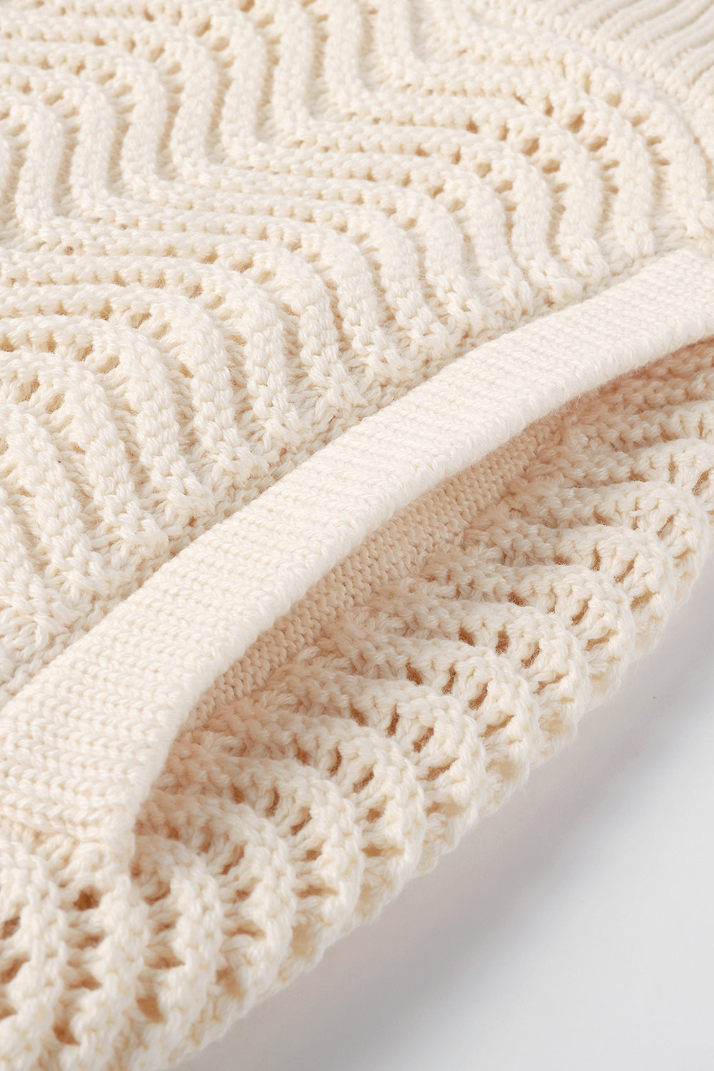 Close-up of white shale stitch knit shorts with side pocket.