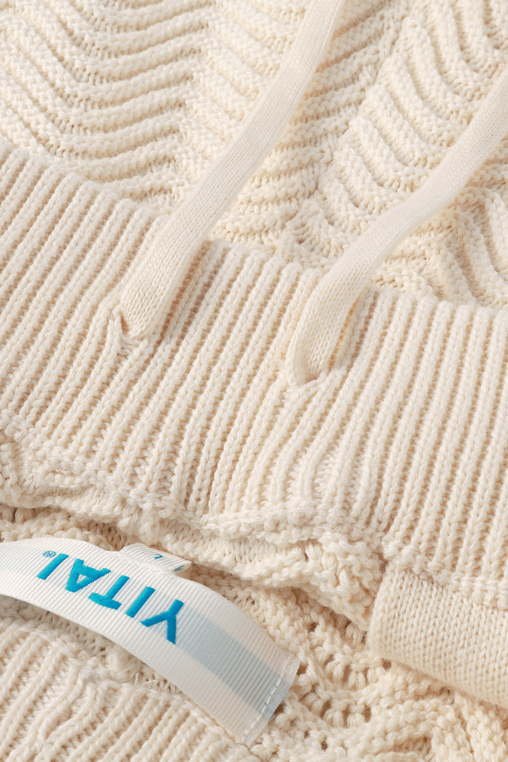 Close-up of textured ivory fabric with a visible label.