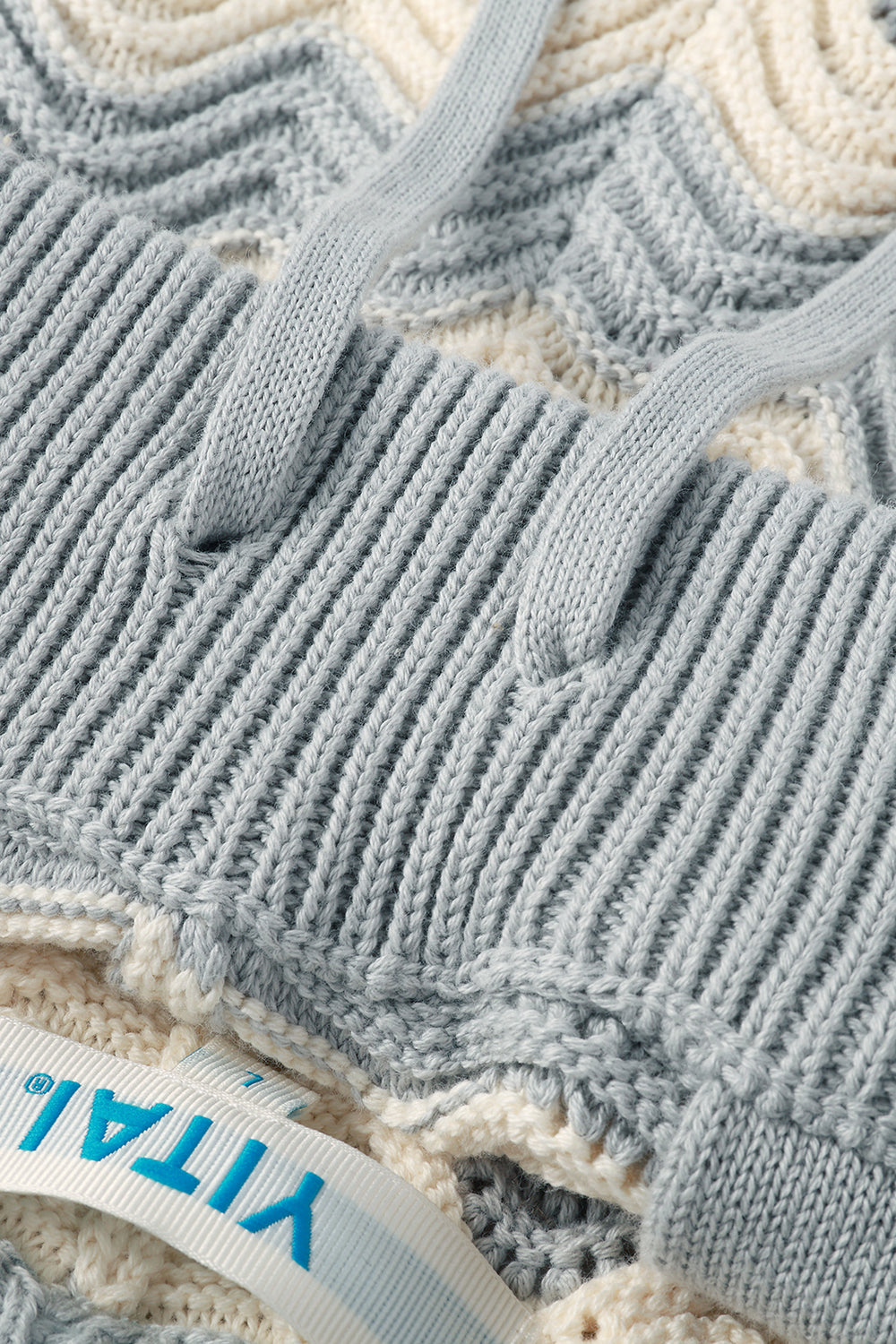 Close-up of a grey textured fabric with a brand label.