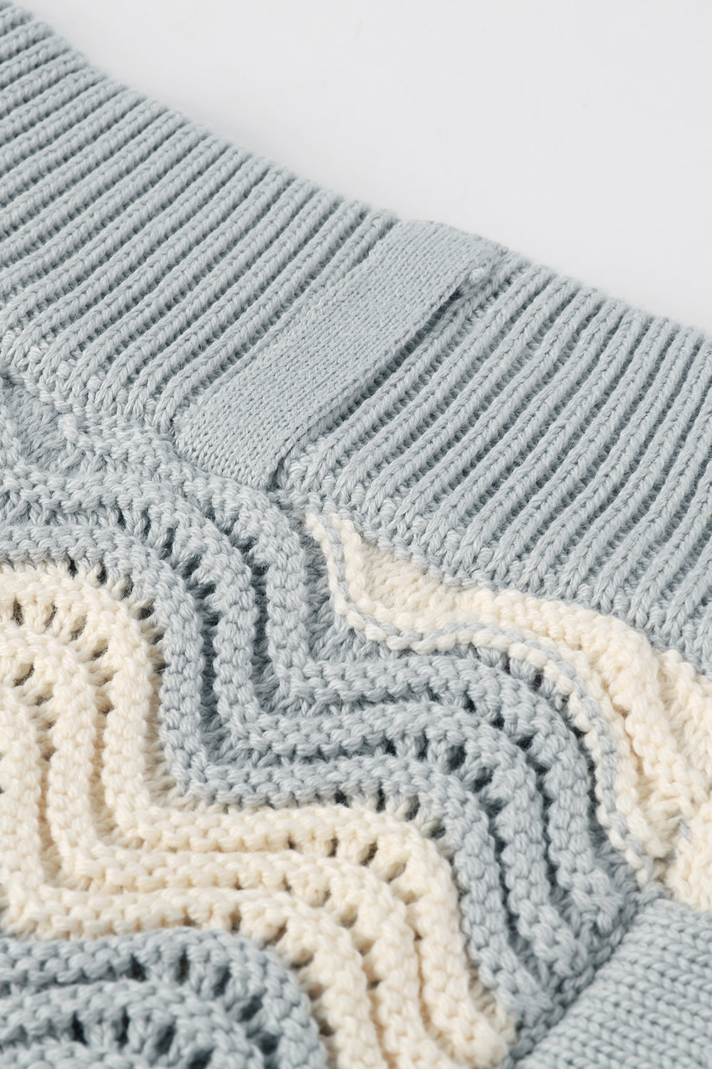 Close-up of grey shale stitch knit shorts with ribbed waistband.