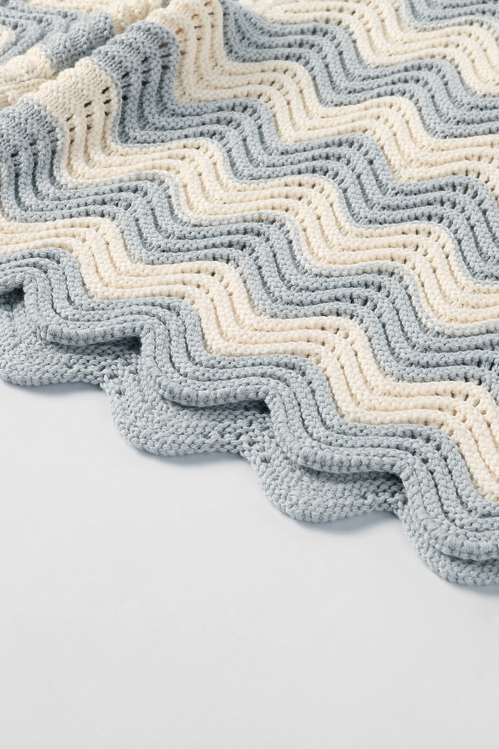 Close-up of grey and white shale stitch knit shorts with scalloped hem.