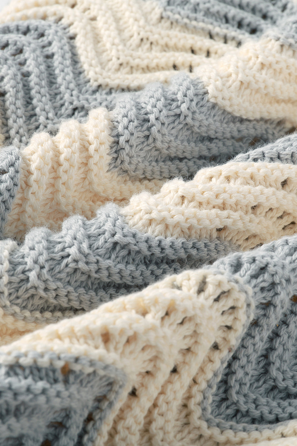 Close-up of grey and white shale stitch knit fabric.