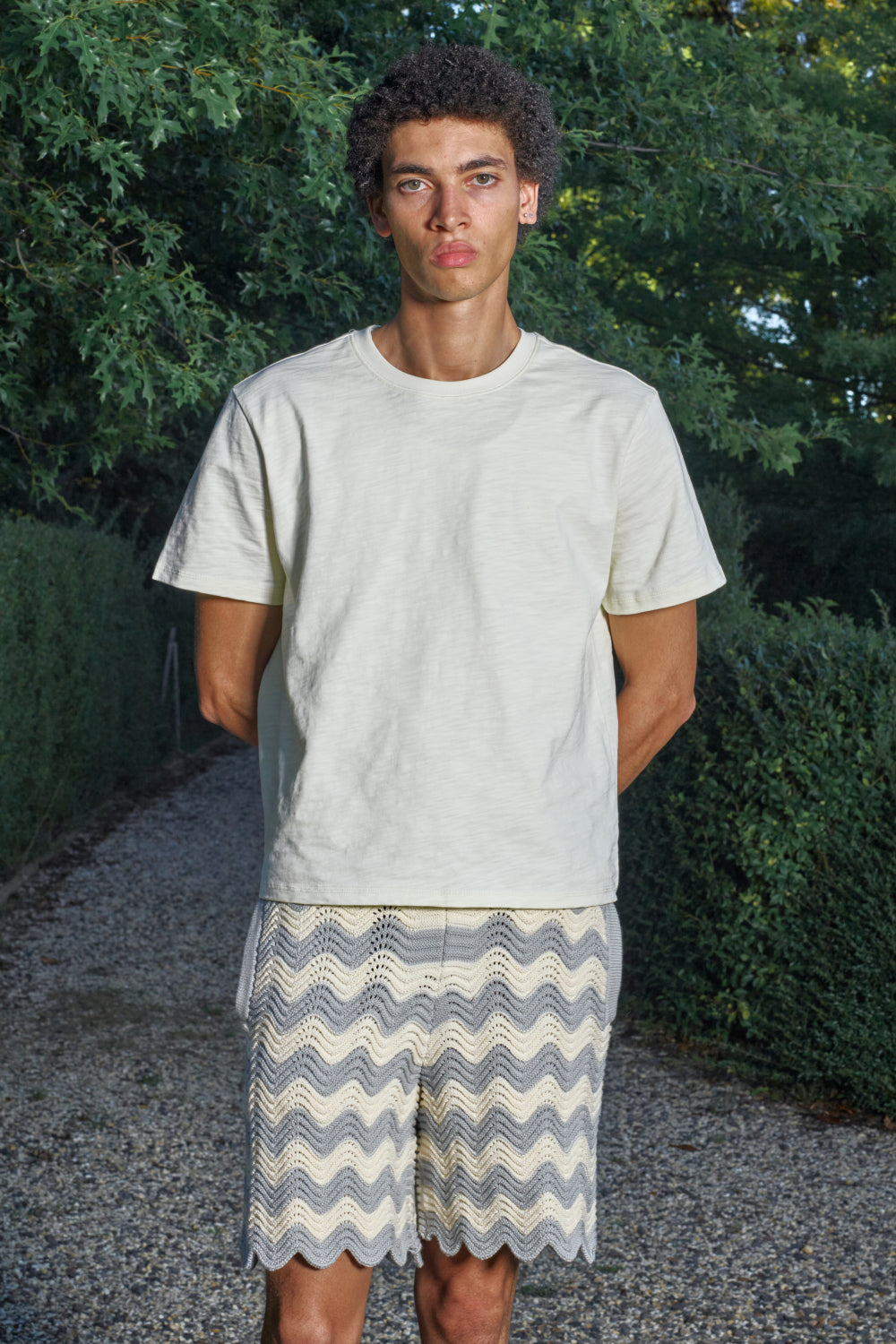 Model wearing grey and white shale stitch knit shorts with a white T-shirt.