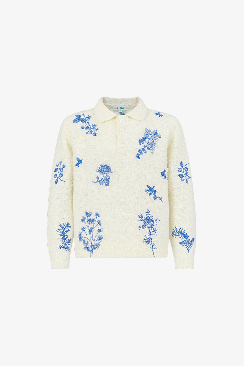 A beige knit shirt with blue floral embroidery, a collar, and mother of pearl buttons.