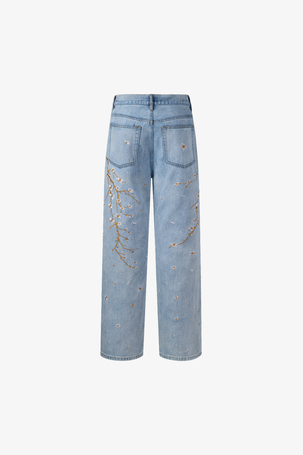 Back view of light blue denim jeans with branch and floral embroidery on a white background