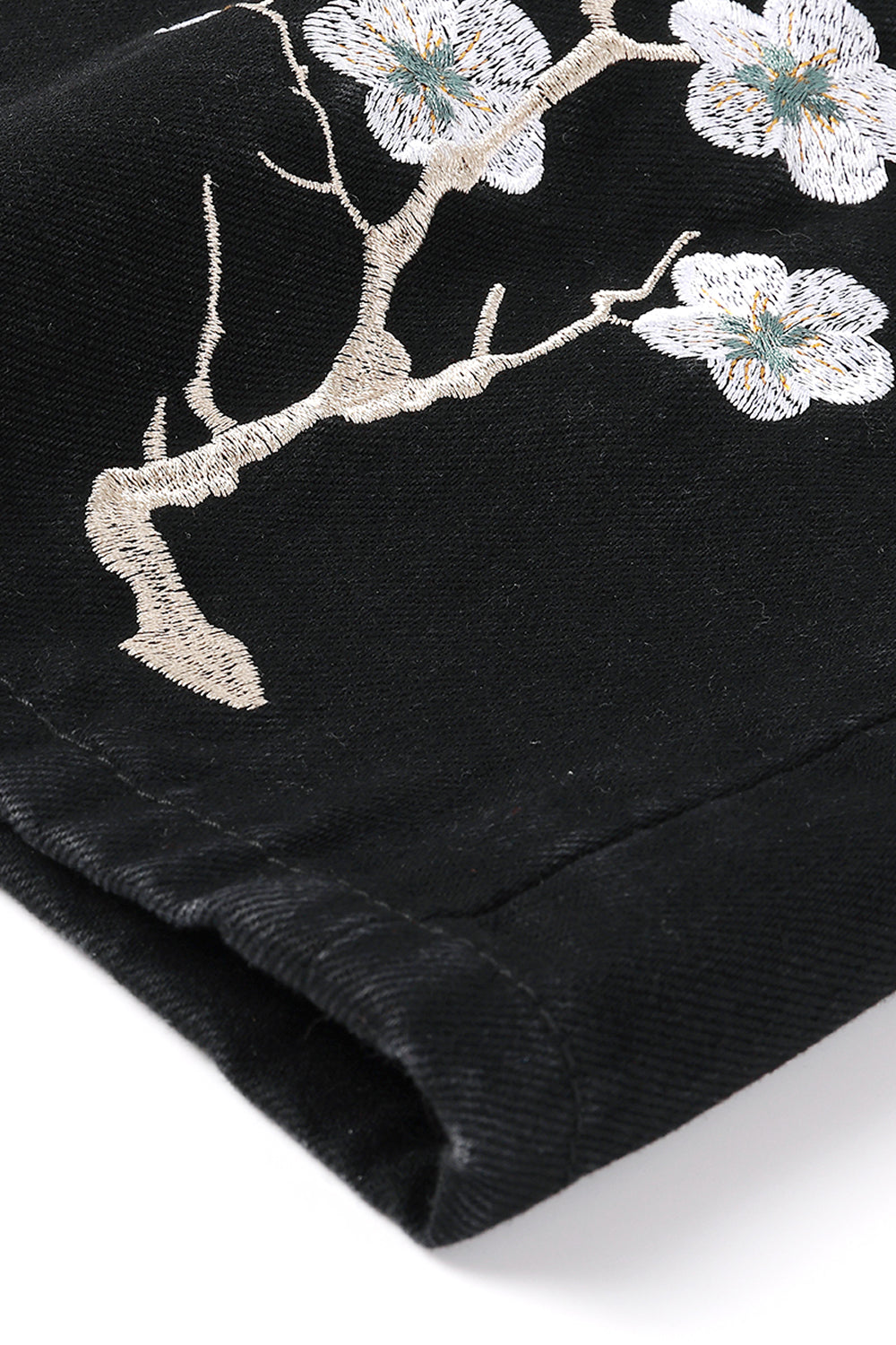 Black fabric with floral embroidery on a white background
