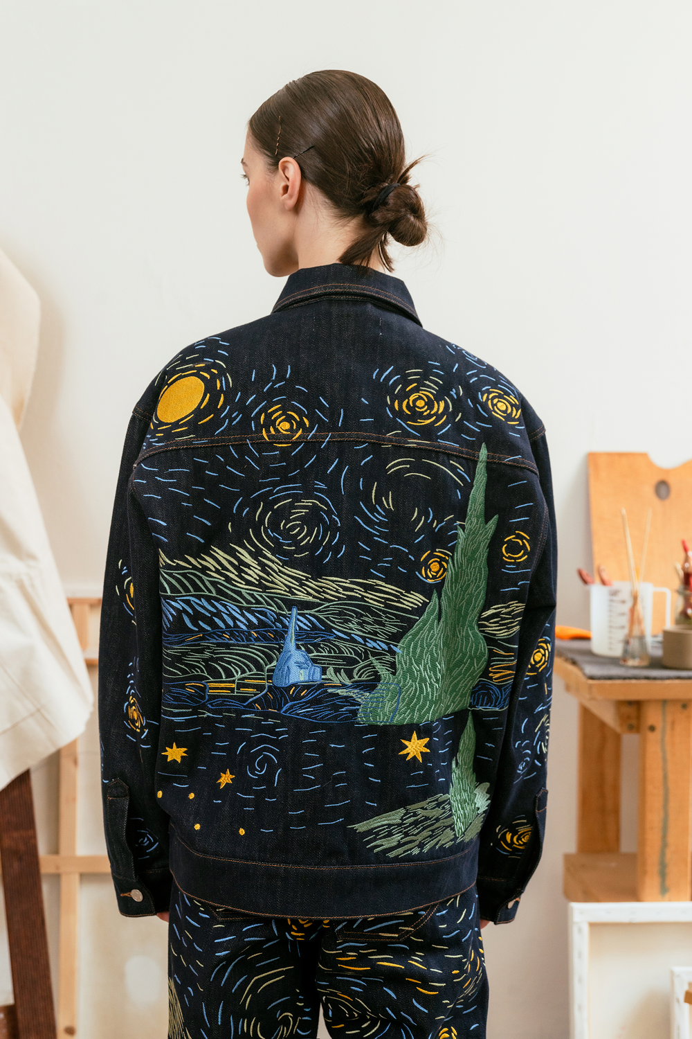 Back view for a person wearing a jacket with 'Starry Night' design in an indoor setting