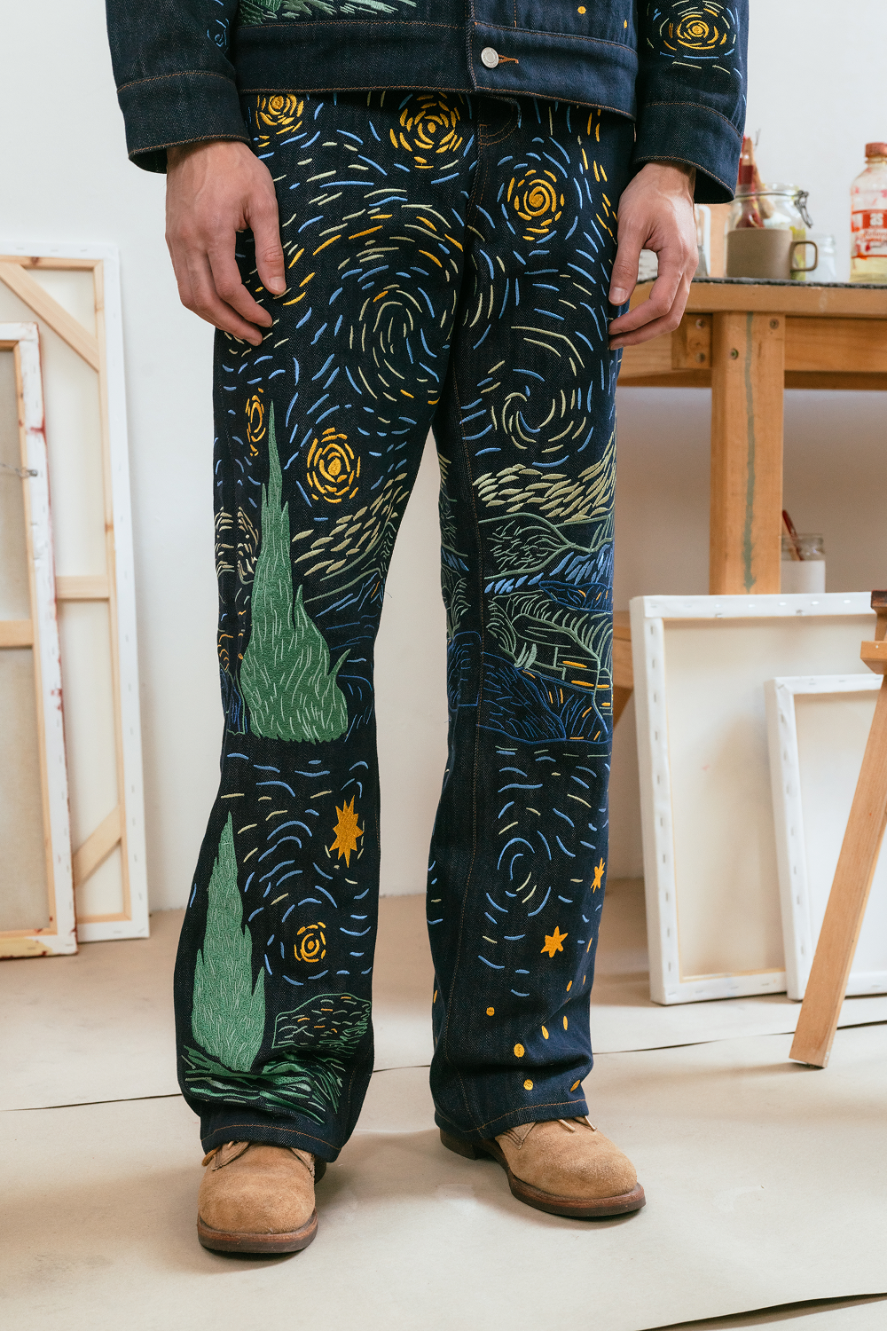 Person wearing a pair of pants with a Van Gogh 'Starry Night' design in an indoor setting.