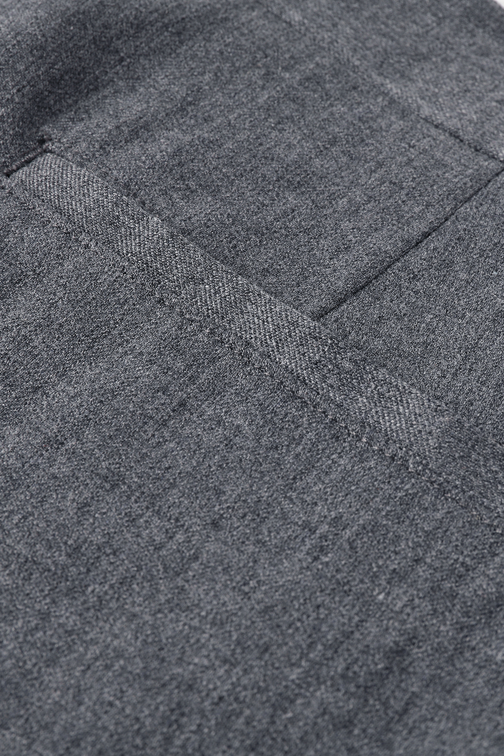 Close-up of grey textured fabric with a stitched pocket detail.