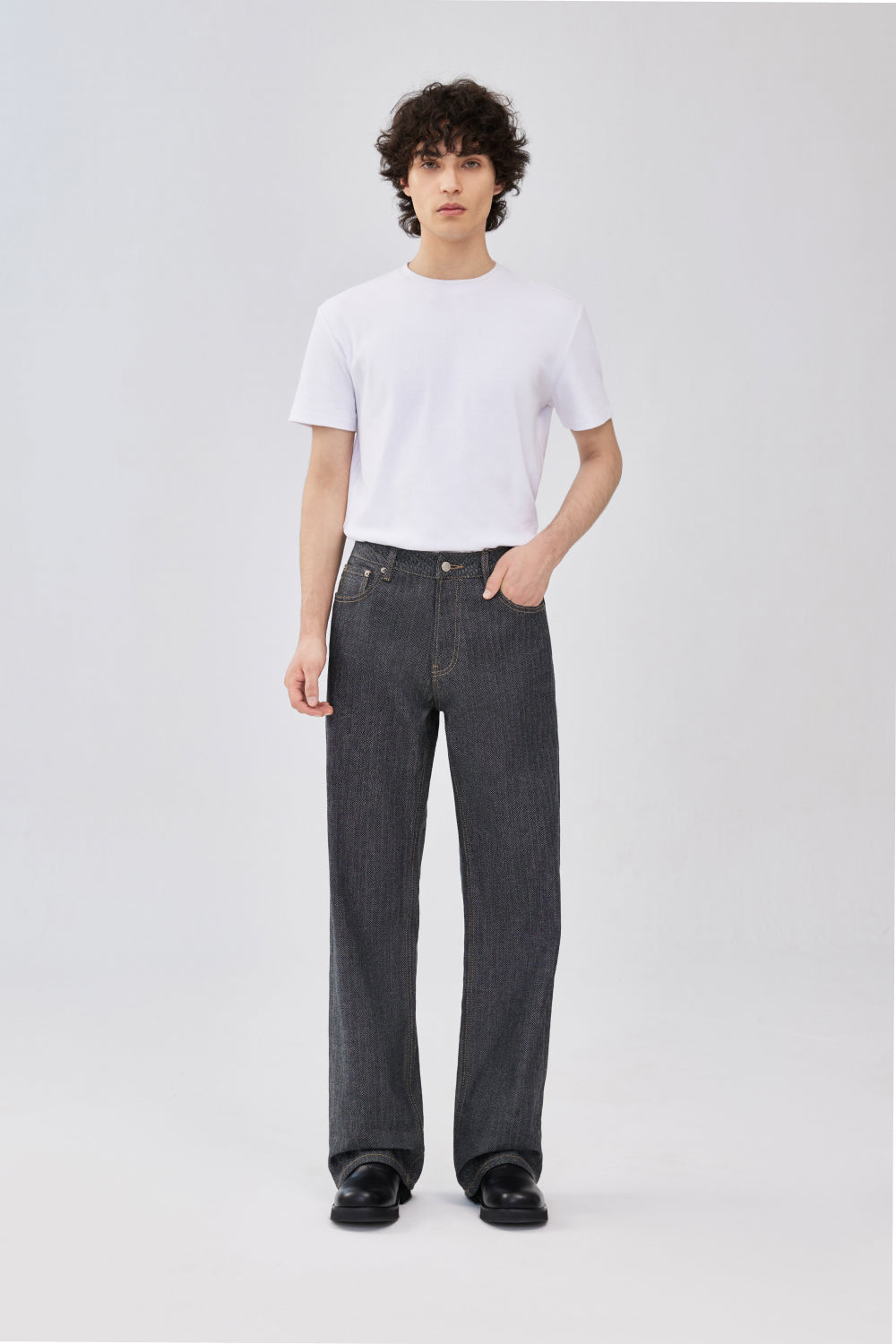 A model wearing a grey herringbone selvedge denim jeans.