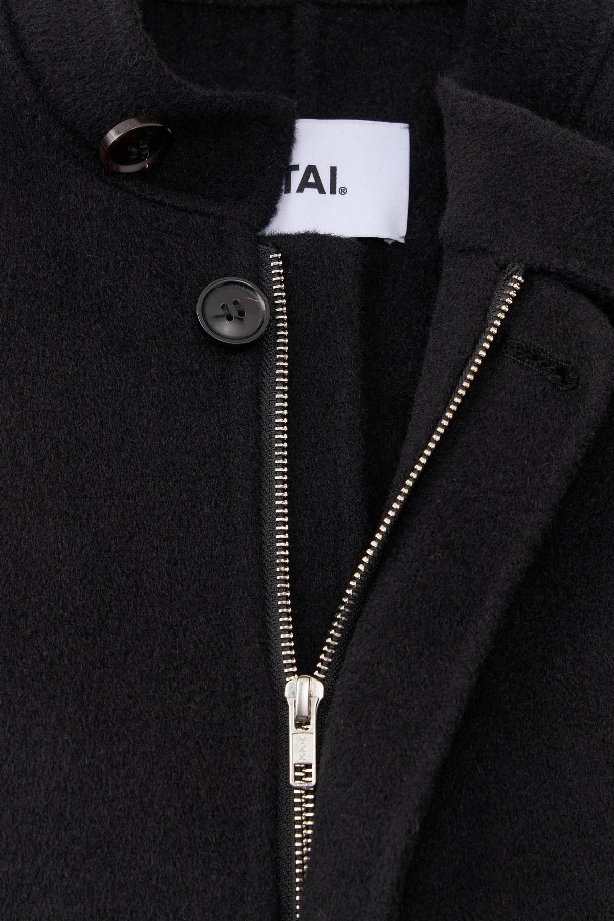 Close-up of the open neckline revealing a white YITAI brand label, silver zipper track, and top button closure.