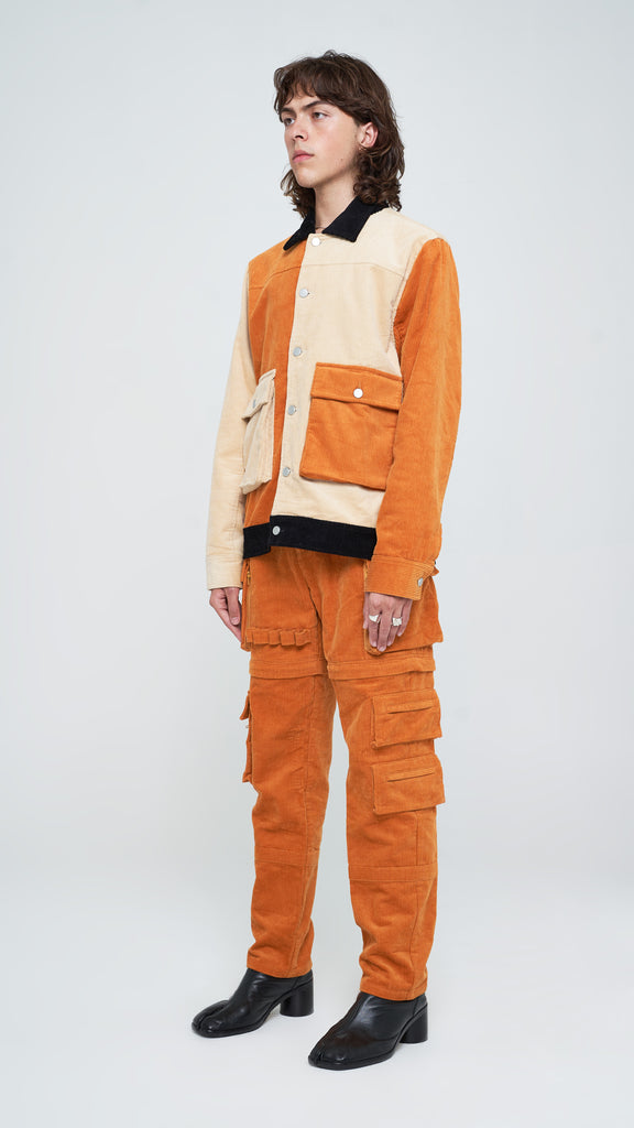 The three-toned corduroy jacket is the perfect piece to add a touch of classic yet subtle style to your rotation. Constructed from pure cotton corduroy and dressed in Apricot Brown, Oatmeal, and Jet Black, this piece is detailed with a classic collar and custom "Y.T.G." button closure. Finished with extended duo cargo pockets with slit inserts on each side, this piece is a must-have in your wardrobe for every season.