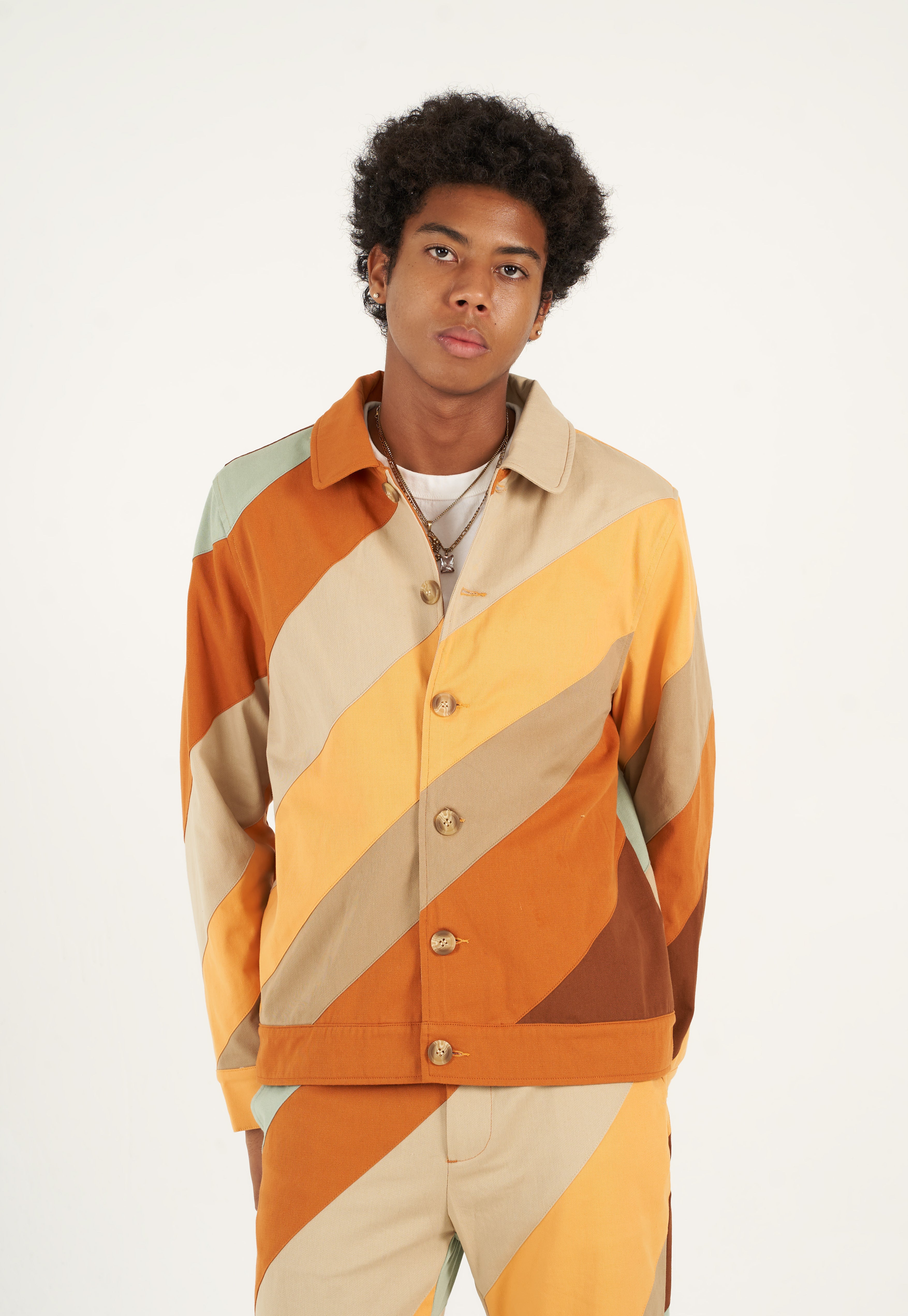 Bringing a touch of fall into your wardrobe, this cotton twill jacket is made using a durable cotton twill. Secured with bone buttons, it has two slit pockets on the sides to storage your everyday essentials. Pair it with our   Diagonal Striped Patchwork Pants to complete your fall and winter look.